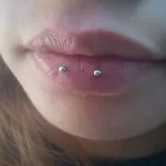 A surface piercing involves inserting a barbell or a piece of jewelry just under the surface of the skin, creating two visible holes at the entry and exit points. This differs from traditional piercings, which penetrate through a body part (like an ear or nostril). Surface piercings are often performed on flat or curved surfaces, such as the back of the neck (nape), chest, hips, or even the face.