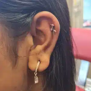Pink titanium vine labret in helix piercing, implant-grade jewelry