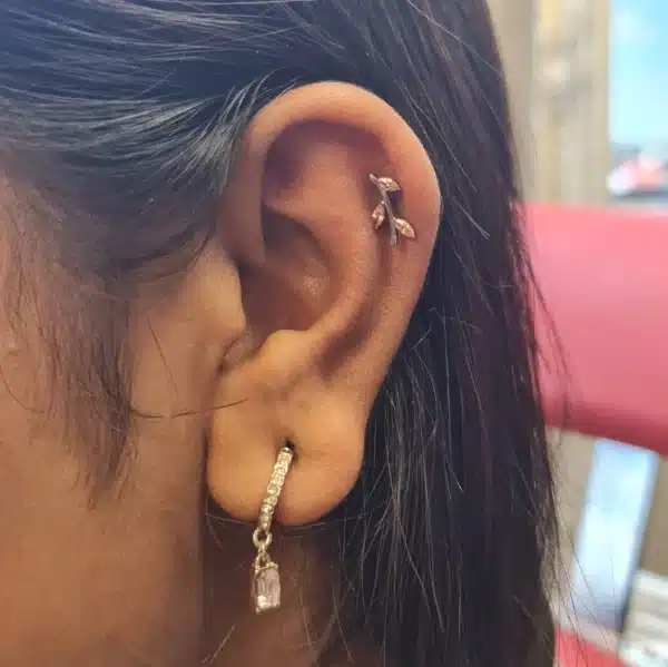 Pink titanium vine labret in helix piercing, implant-grade jewelry